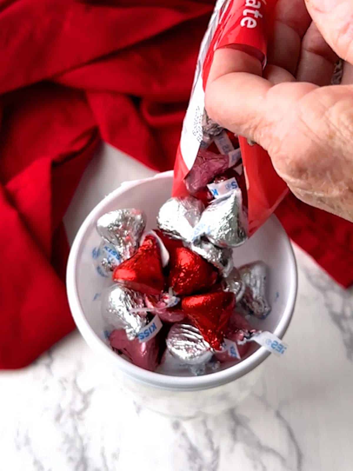 Adding candy to inside of the plastic funnel.