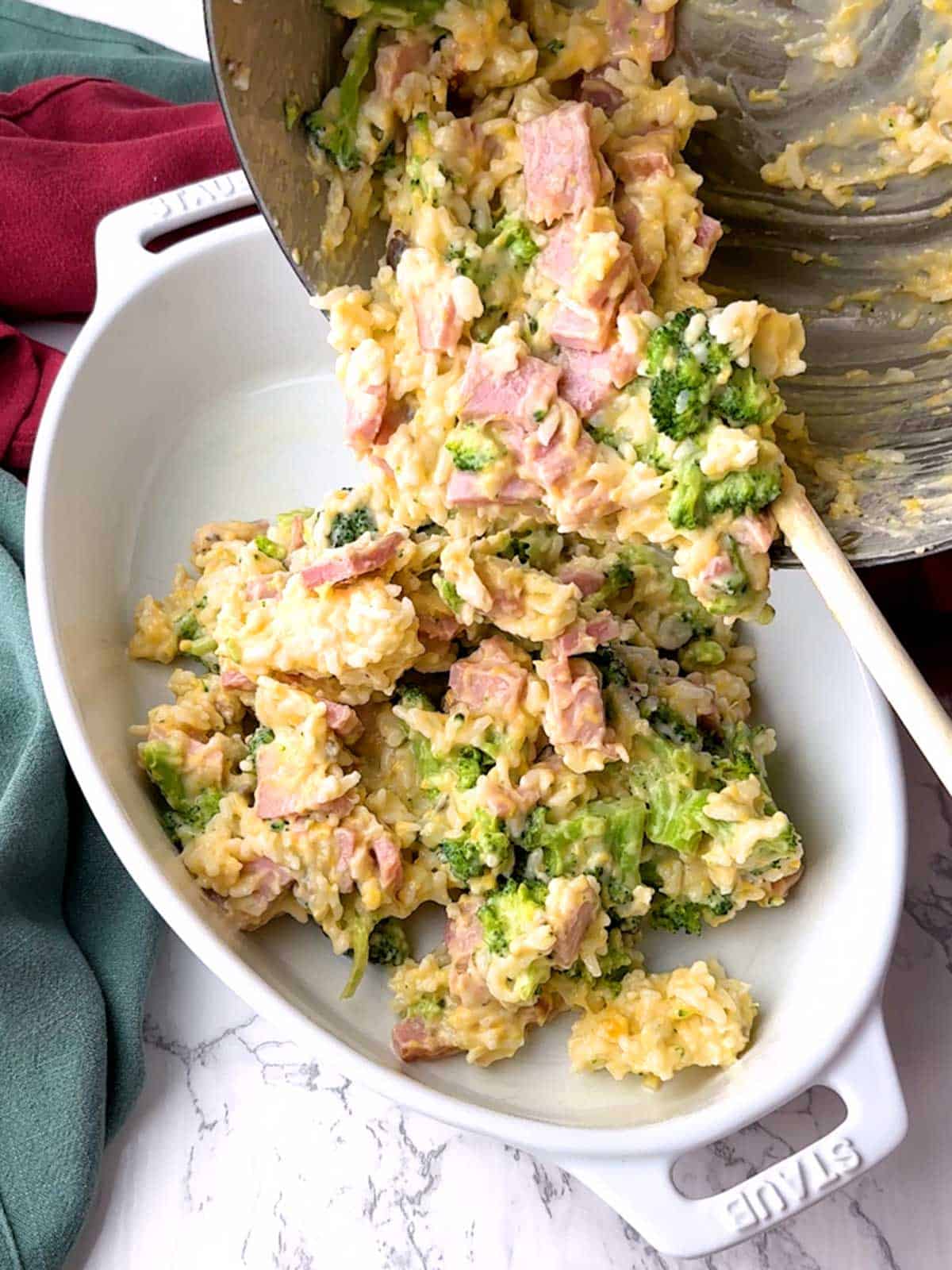 Transferring ham broccoli and rice mixture to a casserole dish.