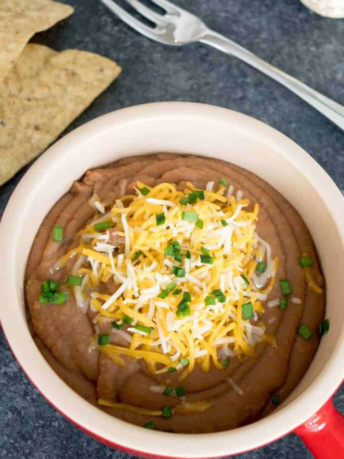 Smashed pinto beans with cheese on top.