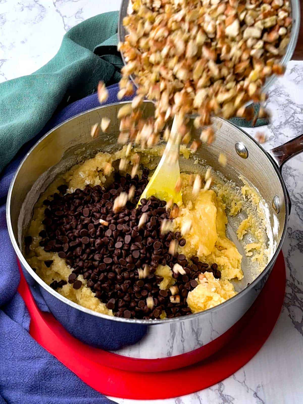 Adding toasted pecans to the cookie brittle dough.