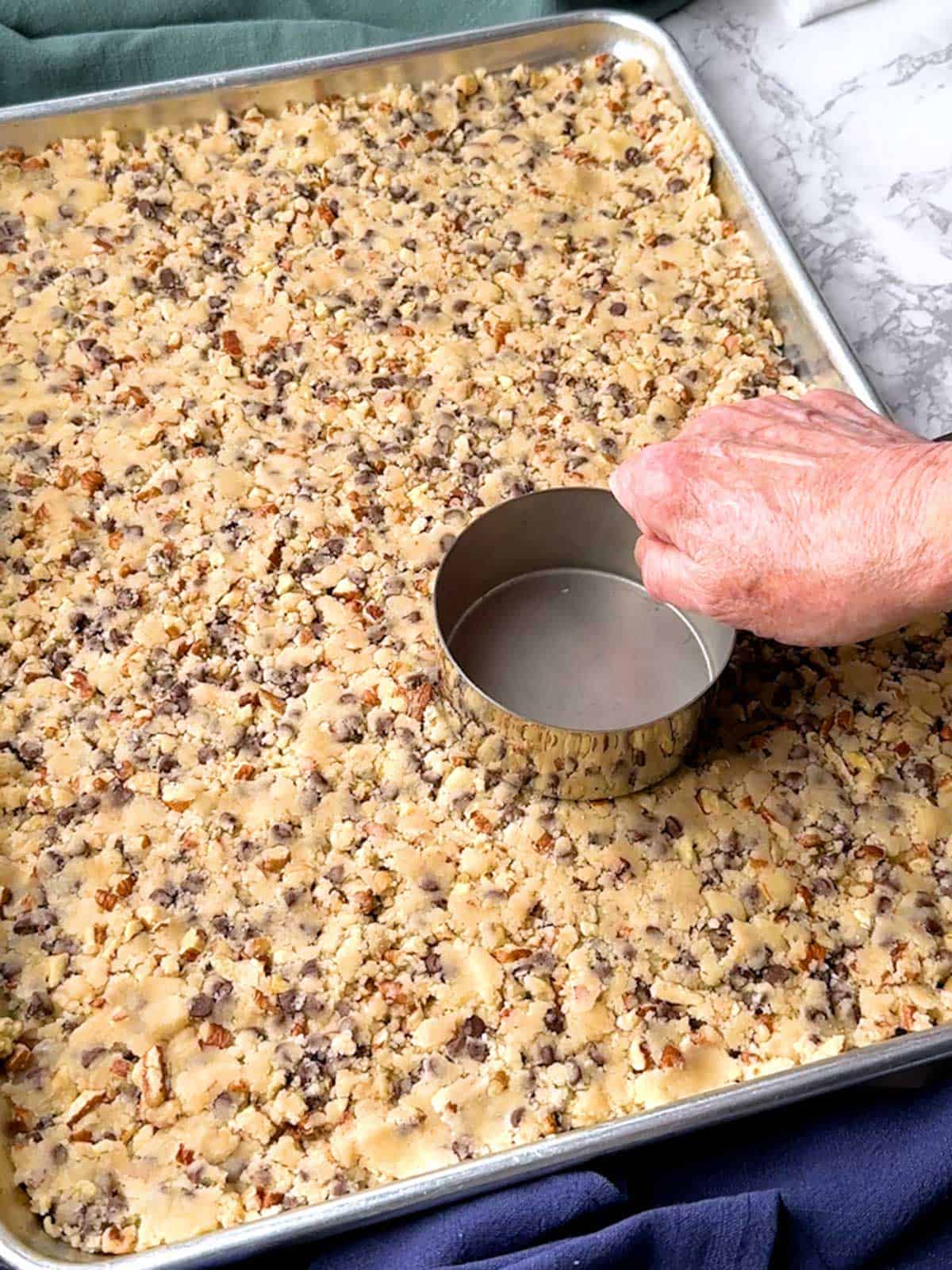 Packing the brittle dough into the large rimmed baking sheet.