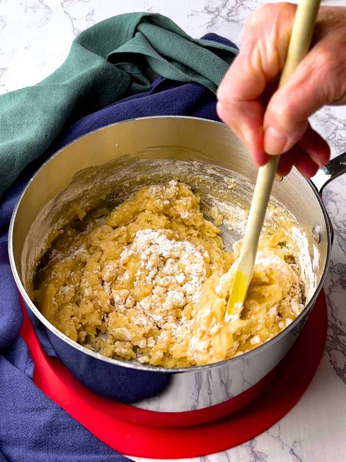 Stirring flour and salt into the butter, sugar and vanilla mixture.