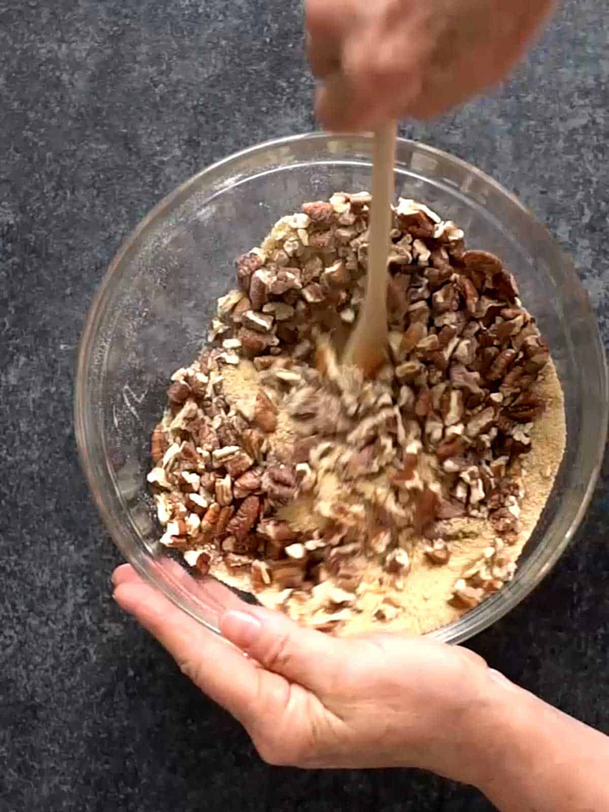 Stirring pecans into the dry ingredients.