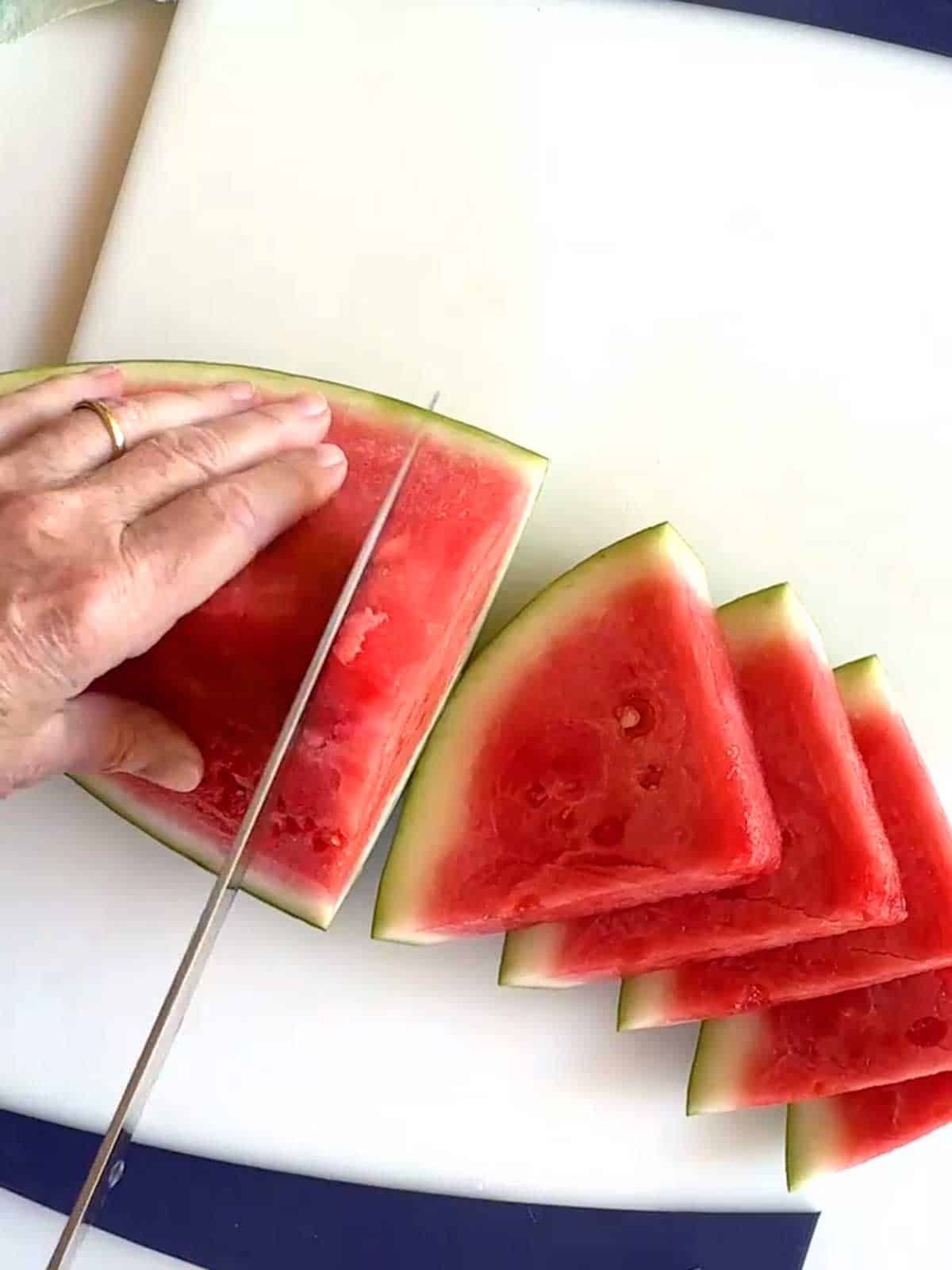 Cutting watermelon quarter into one-inch wedges.