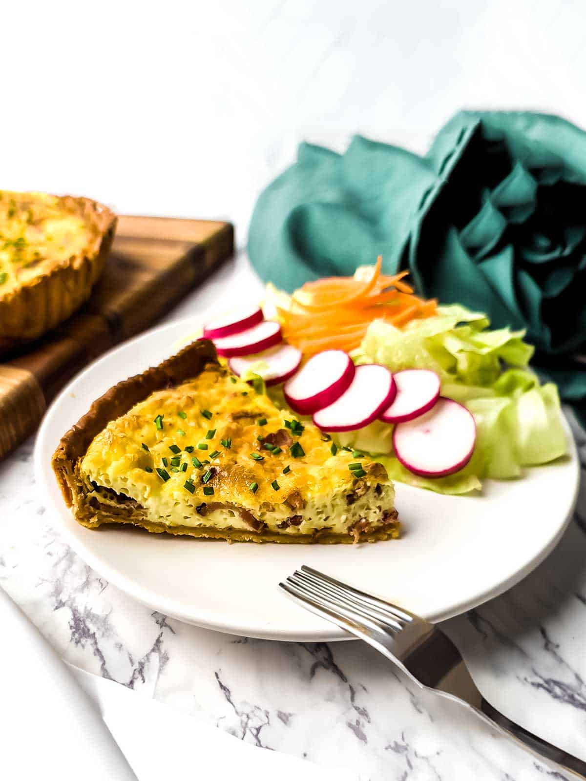 Quiche Lorraine with a salad on a plate.