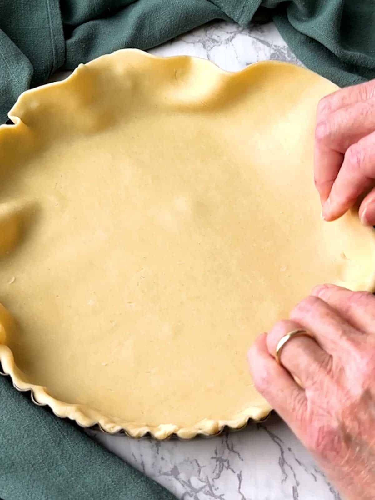 Lining tart pan with pastry.