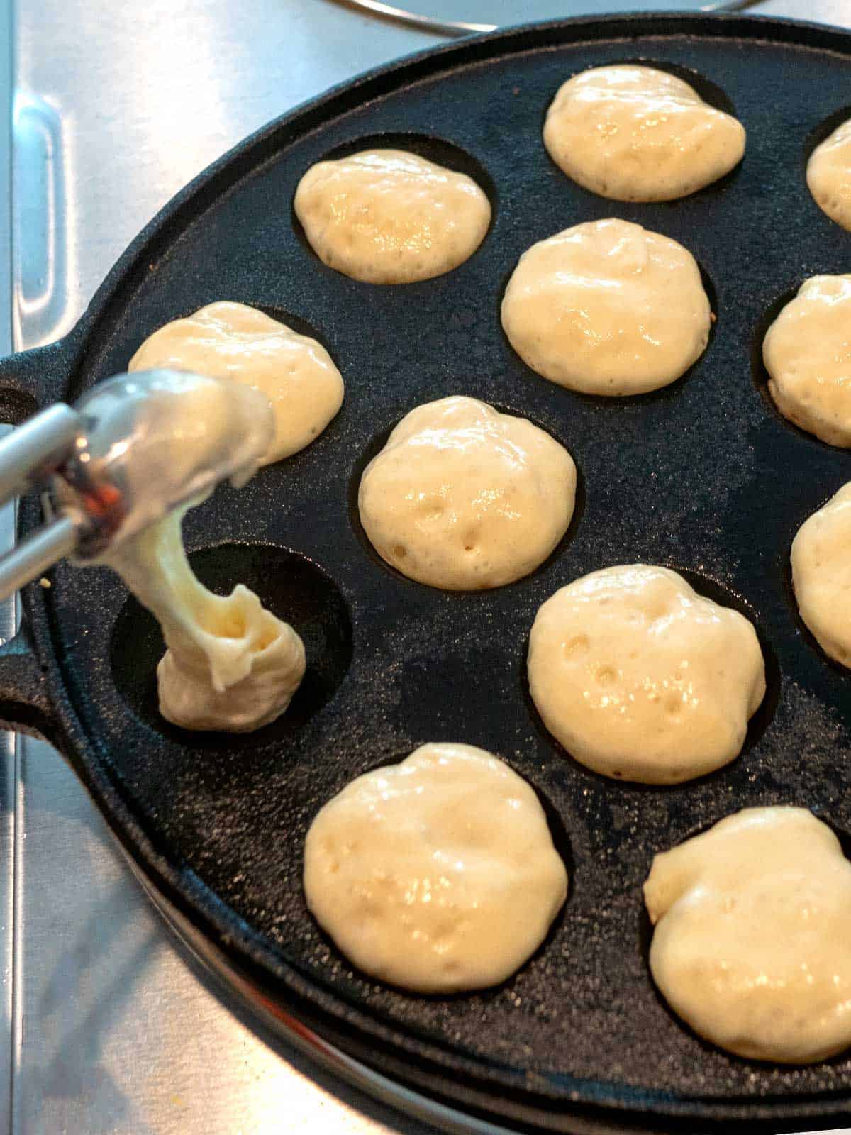 Adding batter to the Poffertjes pan.