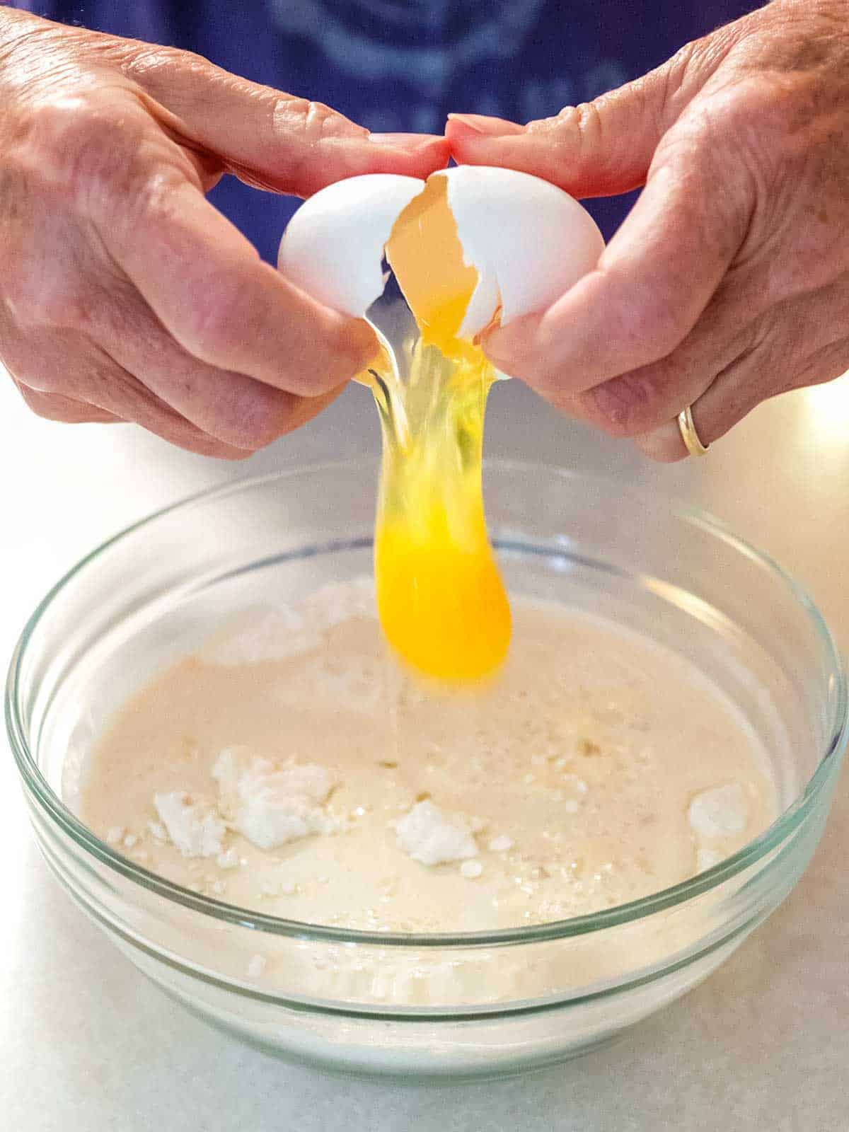 Adding egg to the batter.