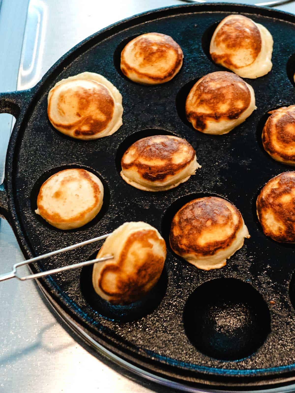 Removing the Poffertjes from the pan.