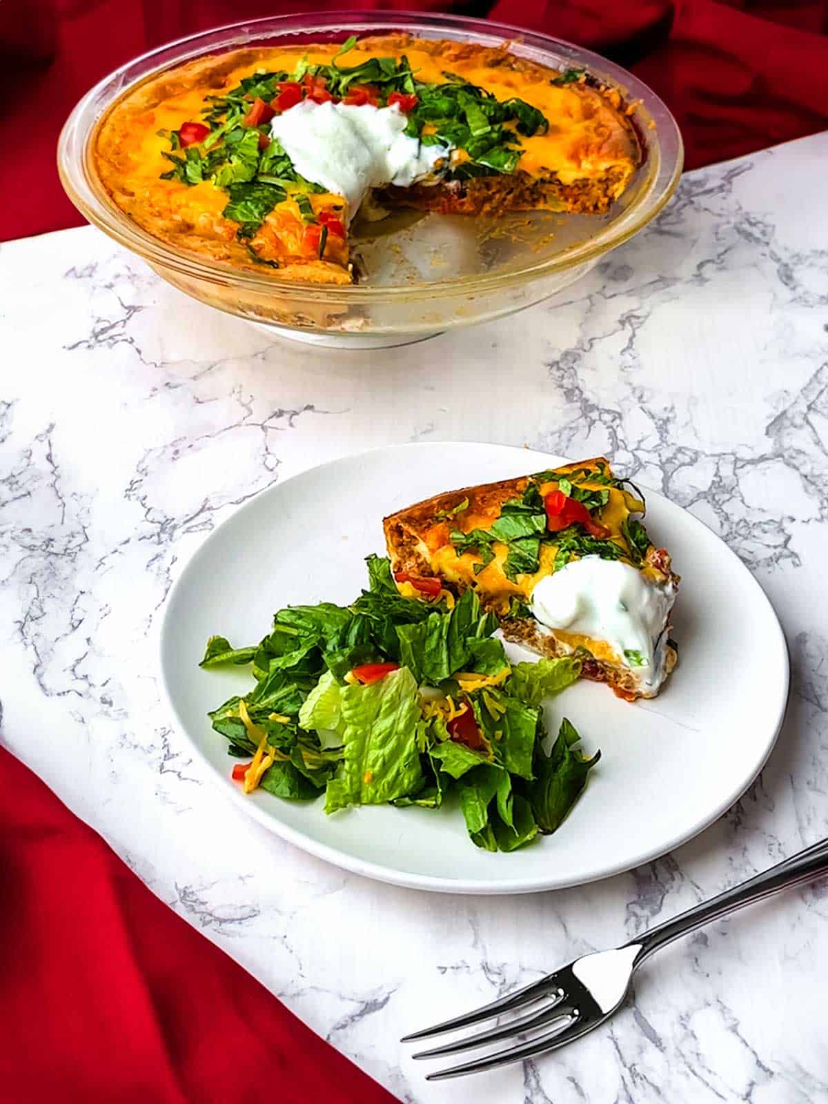 Impossible taco pie with a salad on a plate.
