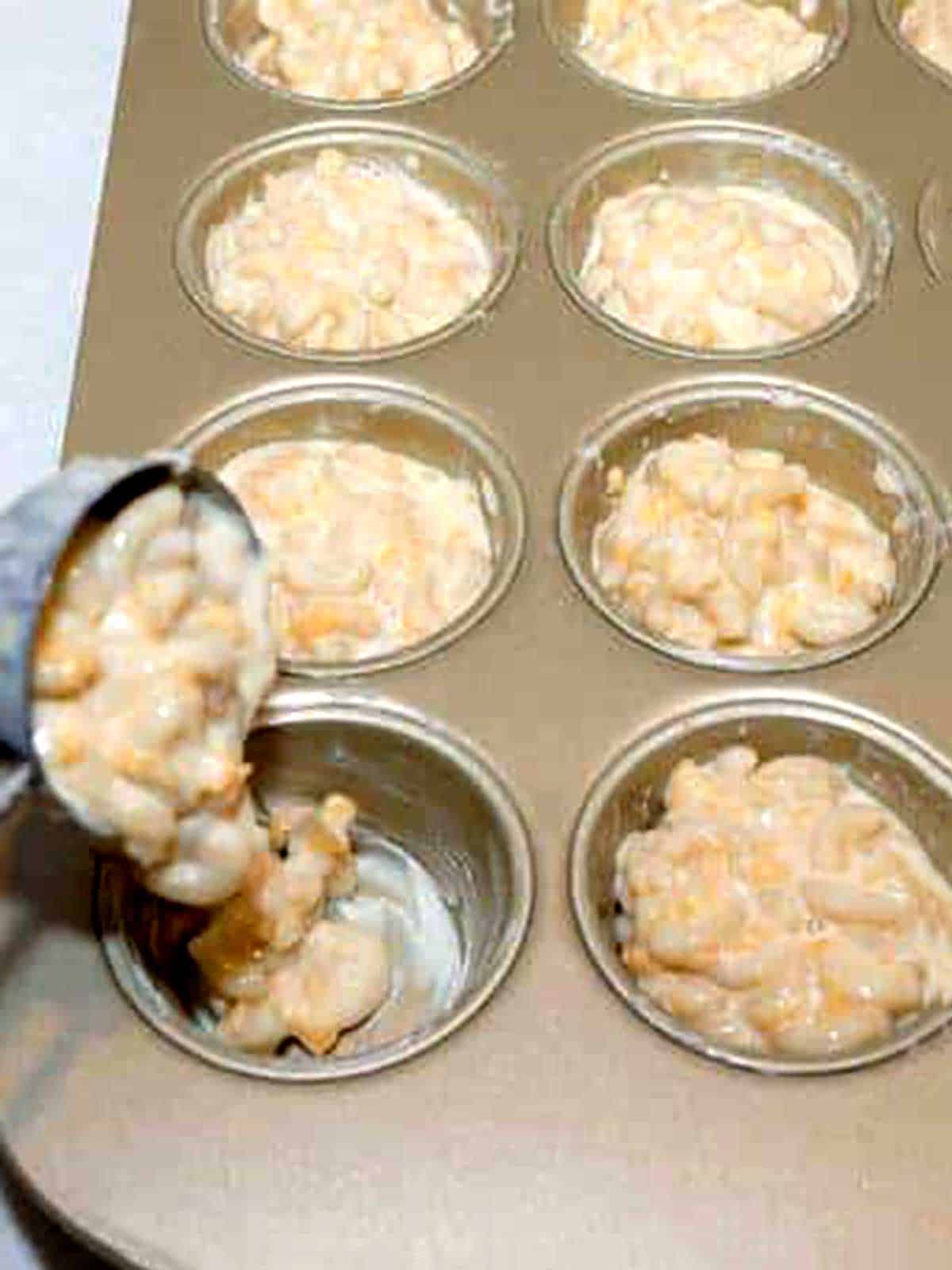 Adding mac and cheese to muffin pan.