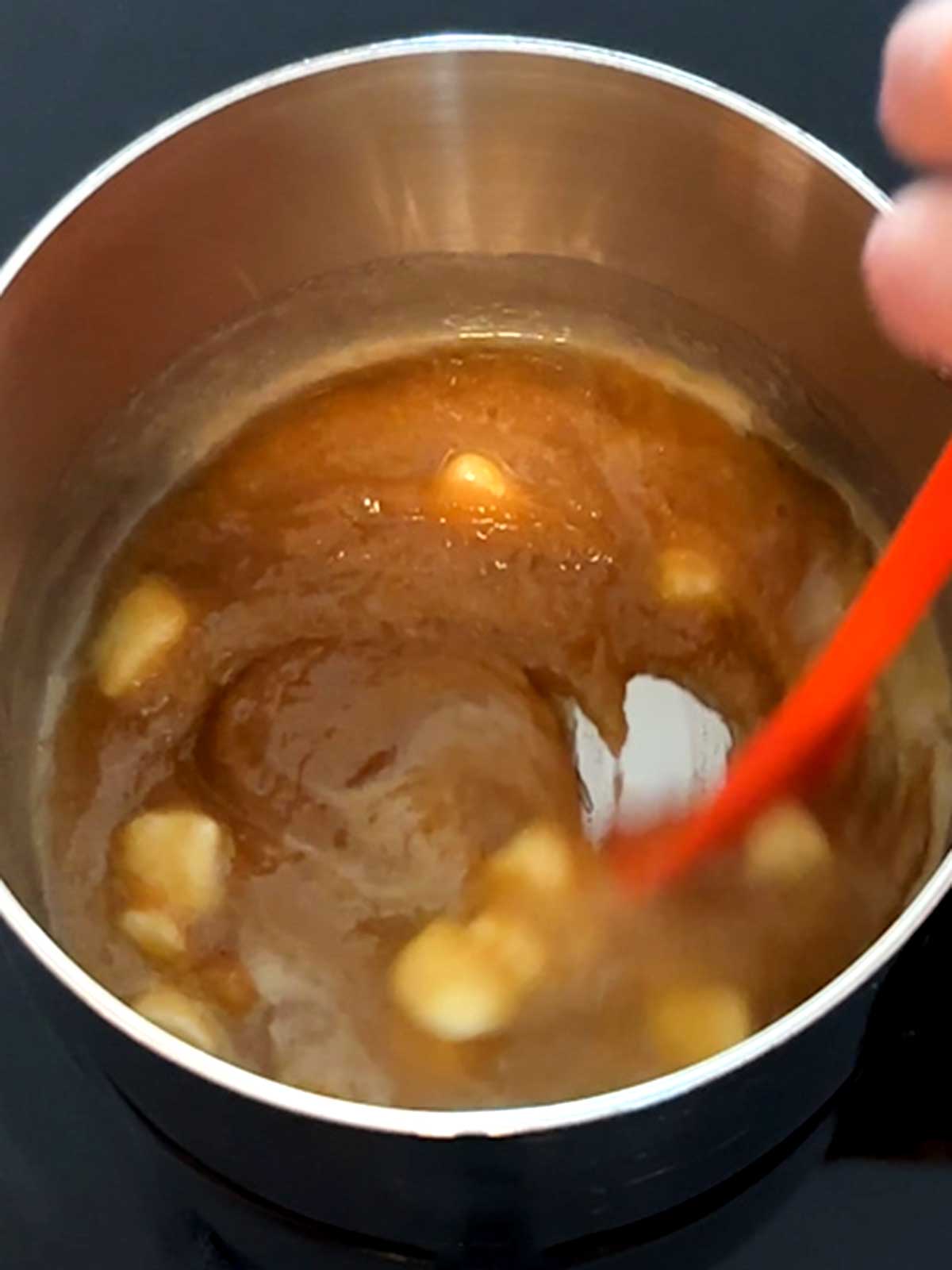 Stirring the caramel mixture until the butter melts.