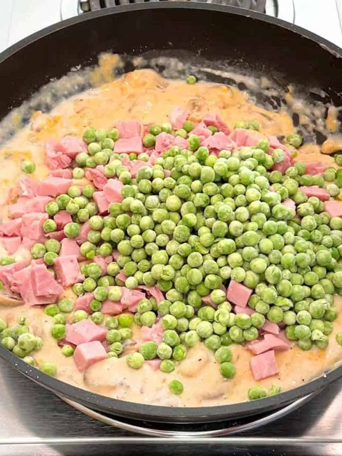 Ham and green peas added to the tetrazzini mixture.