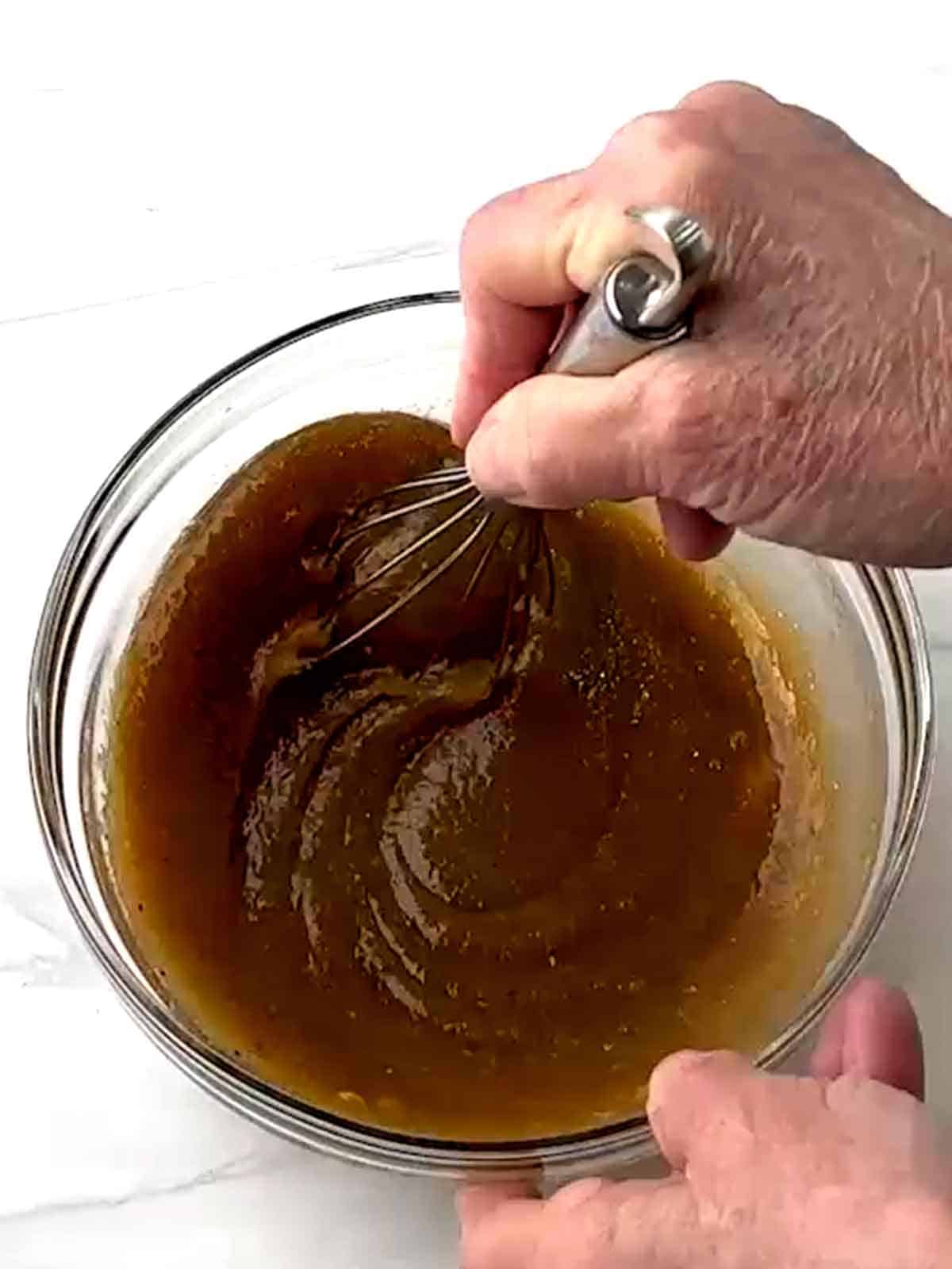 Whisking the glaze ingredients together in a bowl.