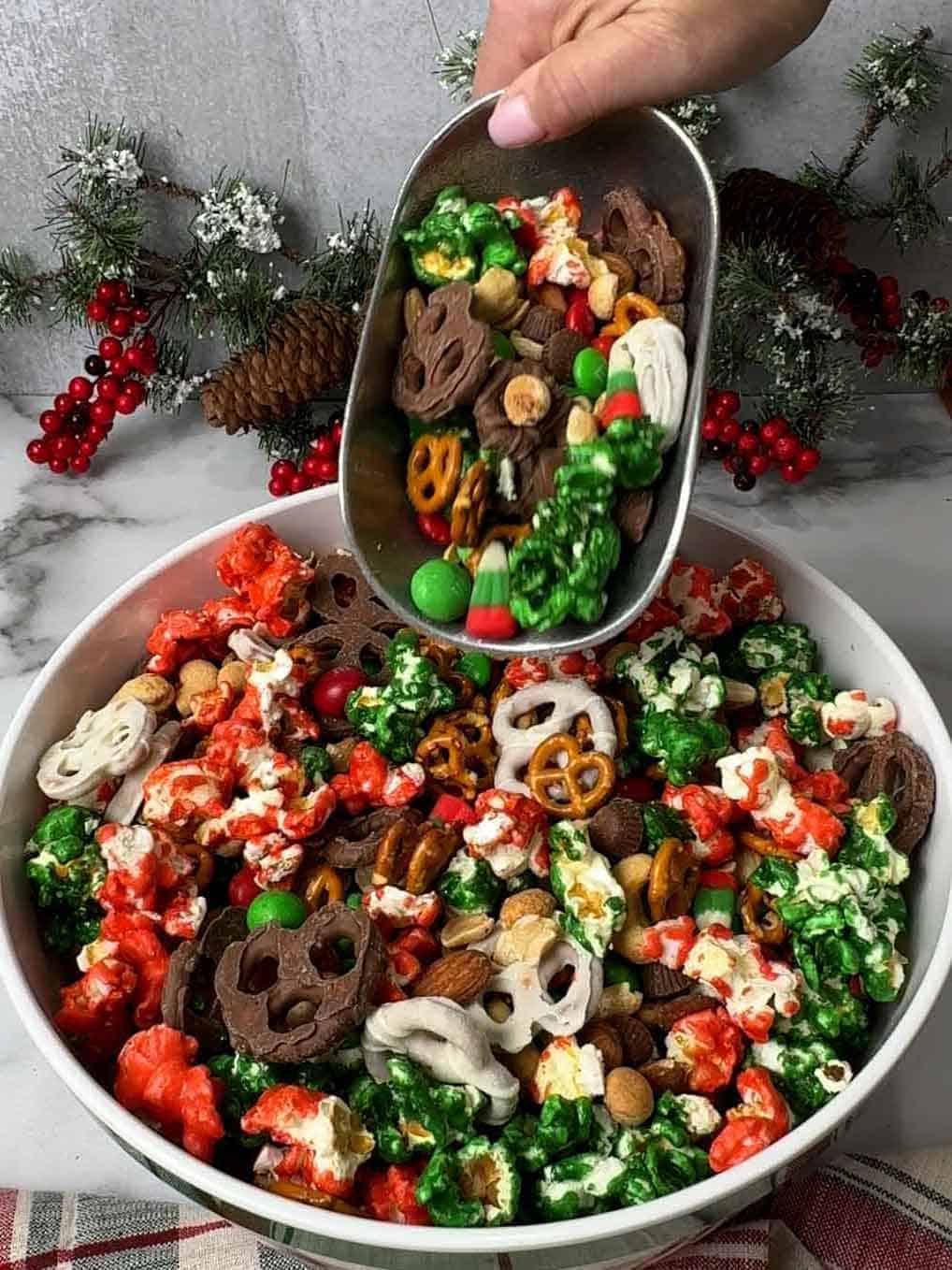 filling bowl with Christmas Snack Mix