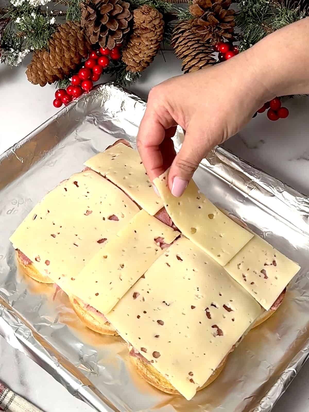 placing swiss cheese on top of ham