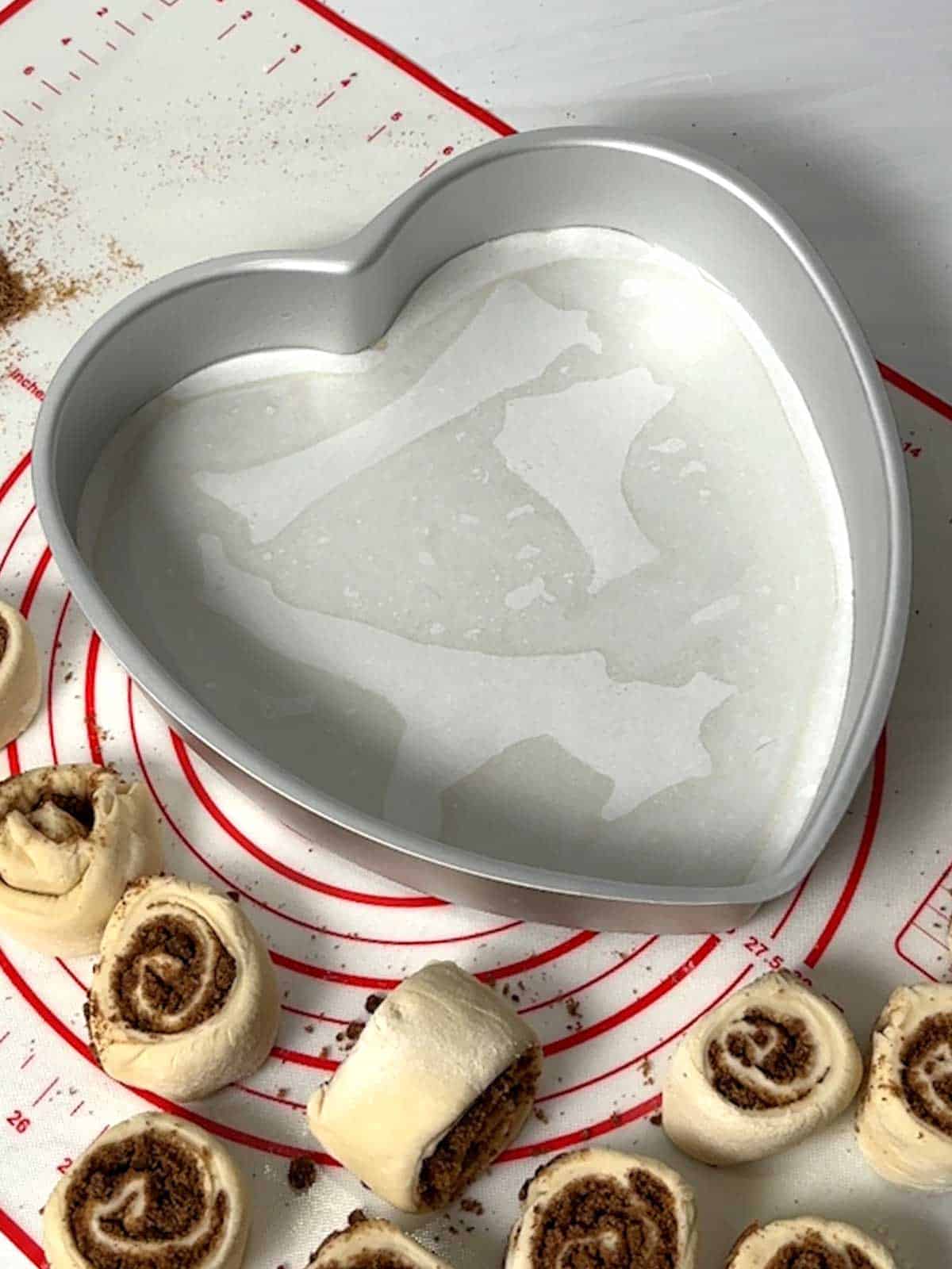 Heart-shaped pan lined with parchment paper.