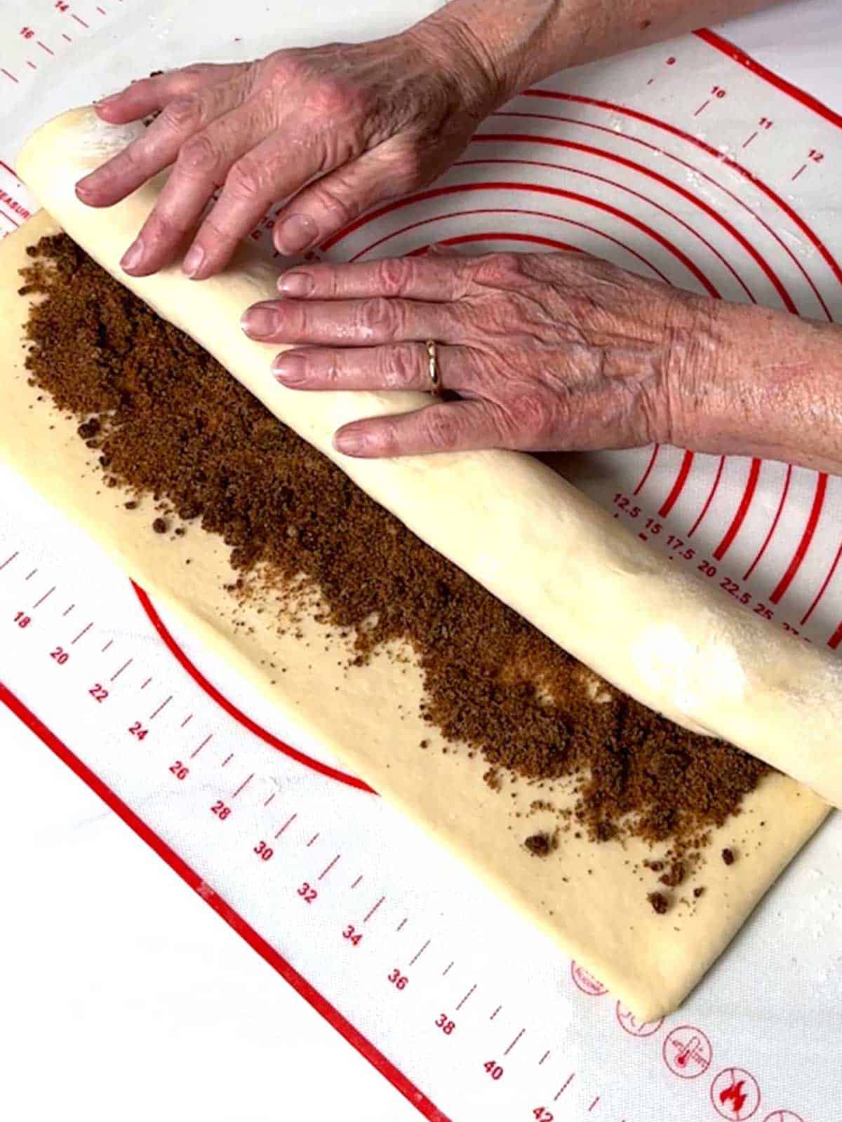 Rolling dough for cinnamon rolls.