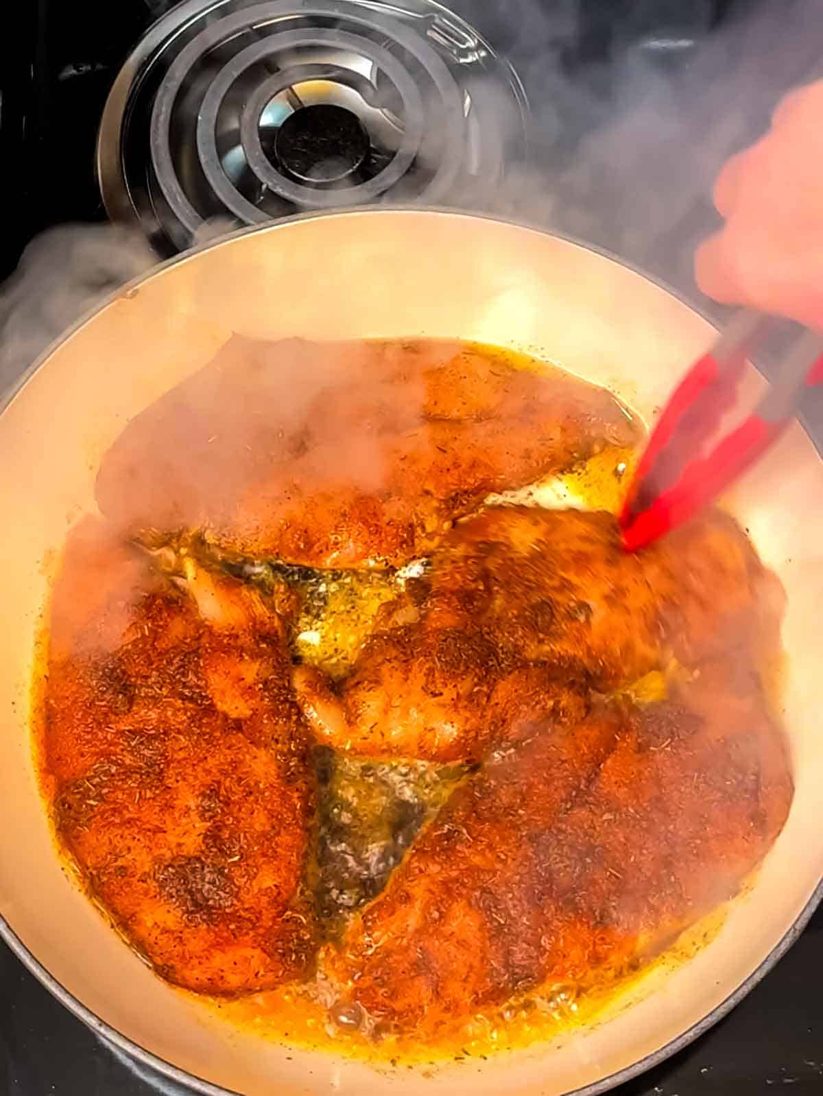 adding seasoned chicken breasts to pan