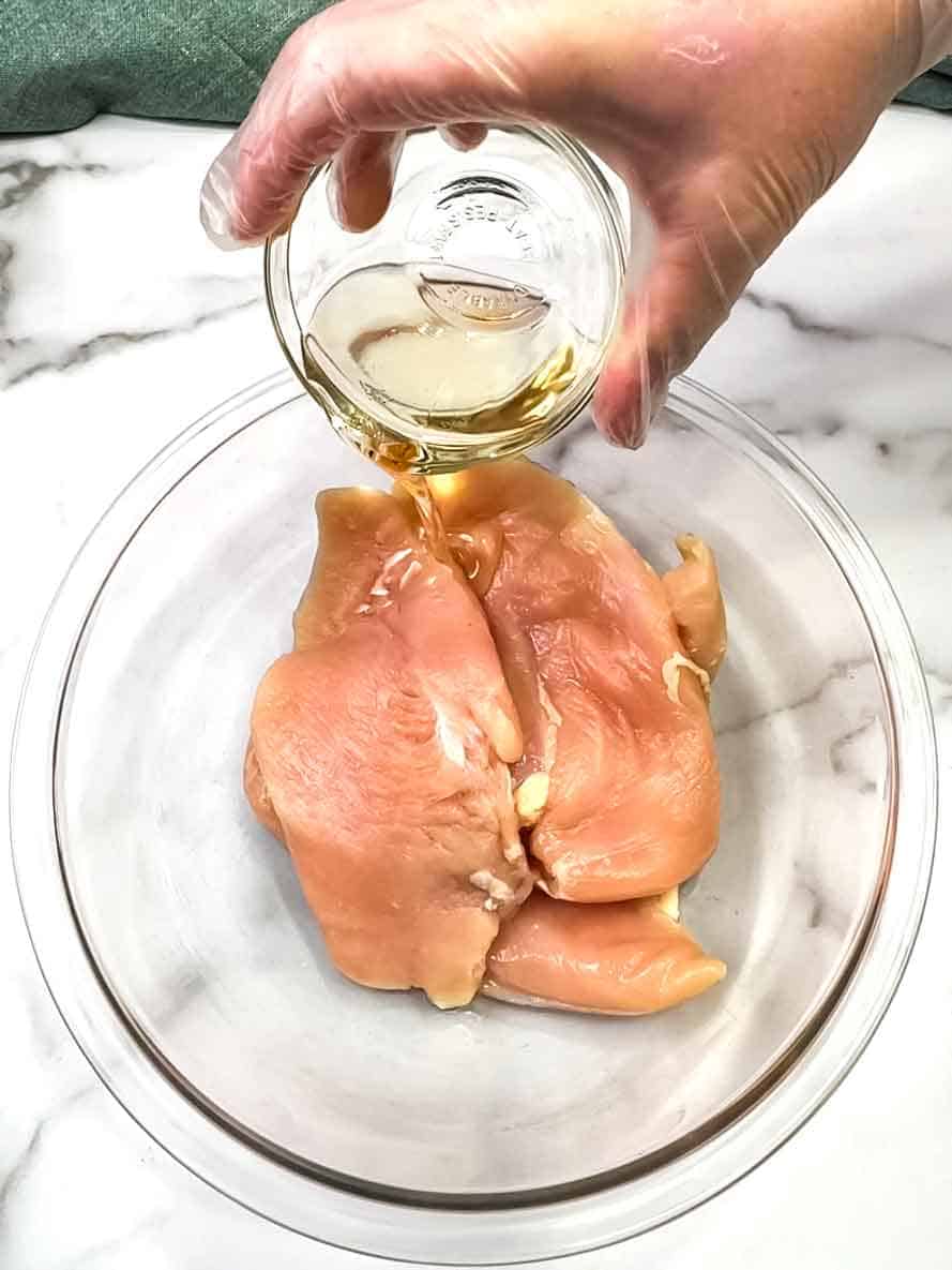 covering chicken breast with olive oil