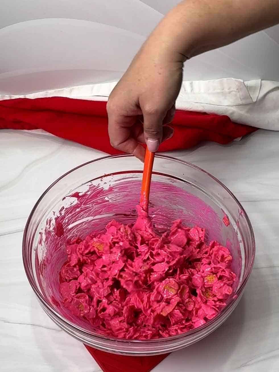 stirring corn flakes and bright pink melted candy