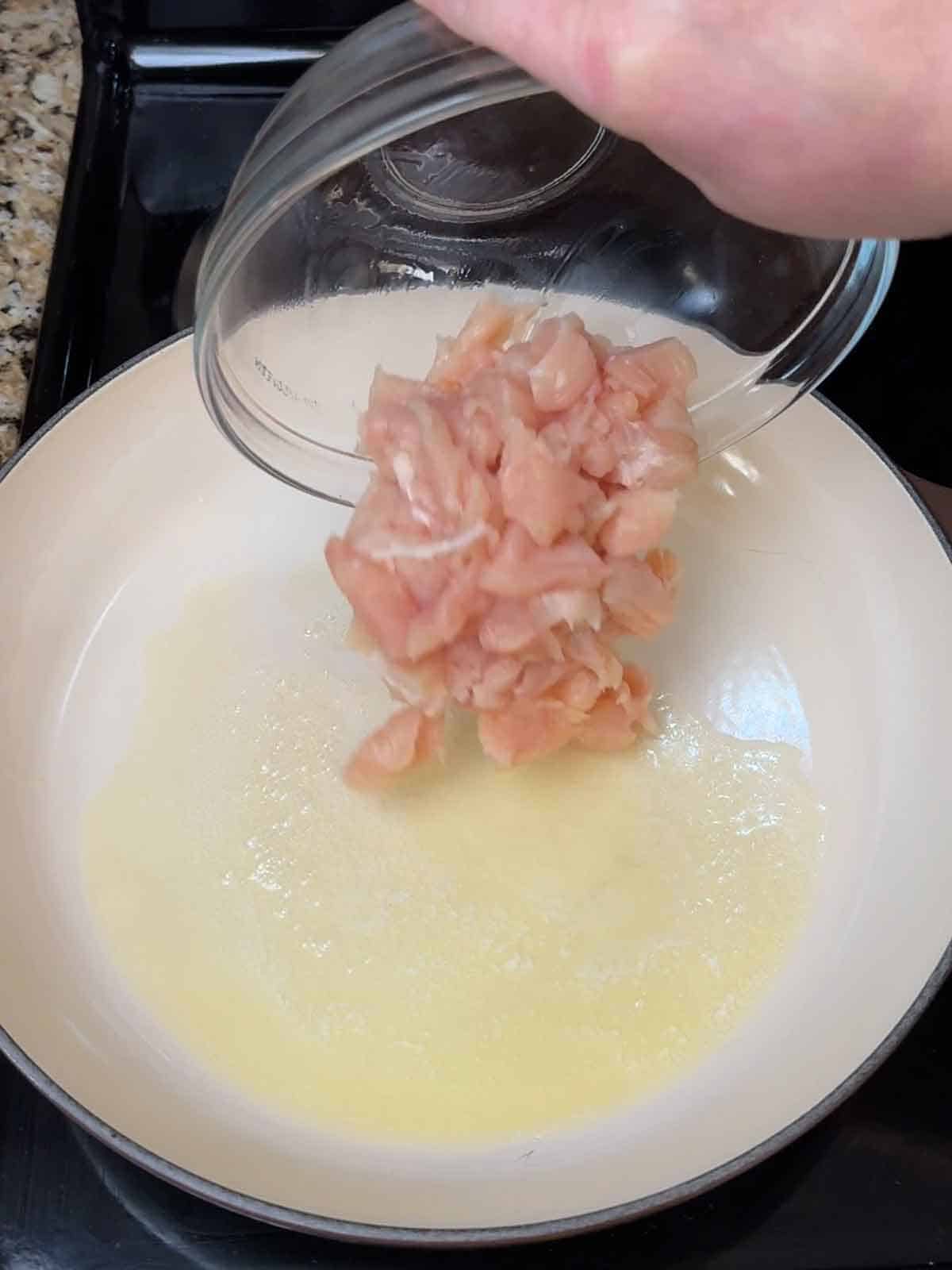 adding cut chicken pieces to melted butter