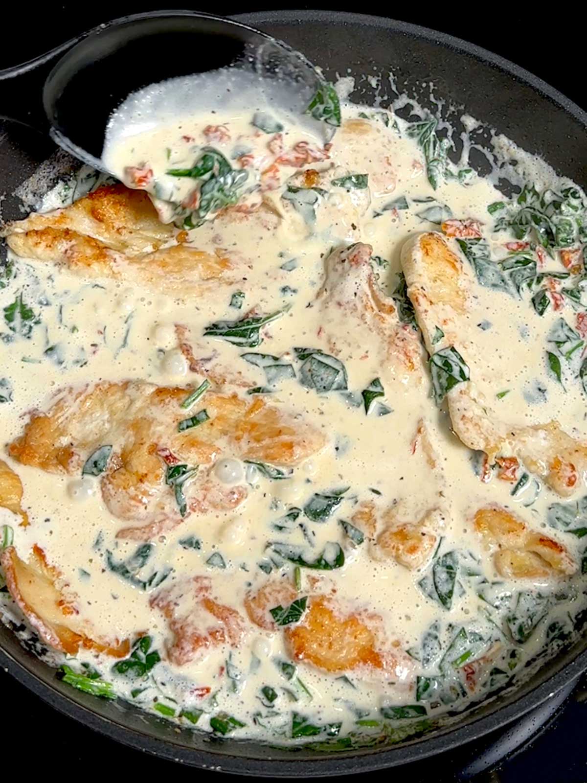 Cooking the chicken in the creamy sauce.