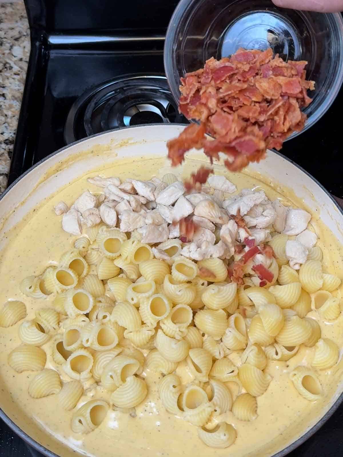 Adding cooked chicken and crumbled bacon