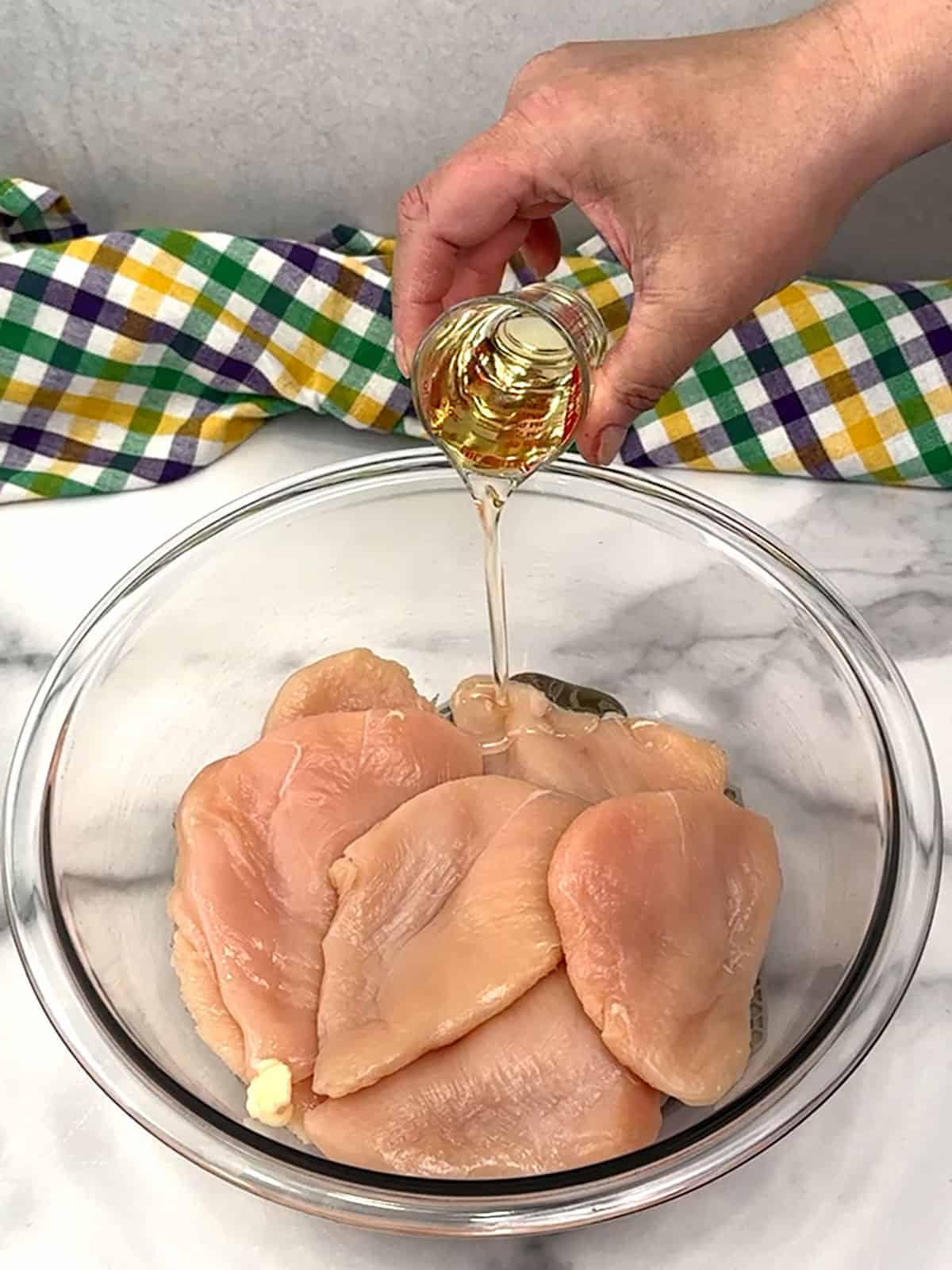 pouring oil over chicken breasts