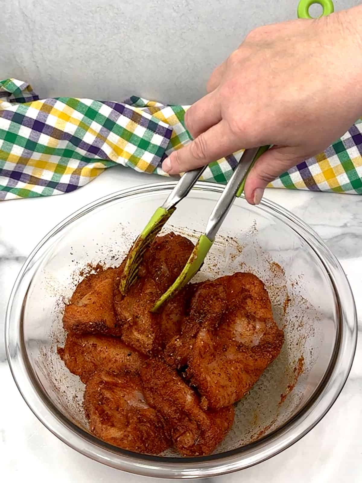 stirring breasts with tongs to coat them in cajun seasoning