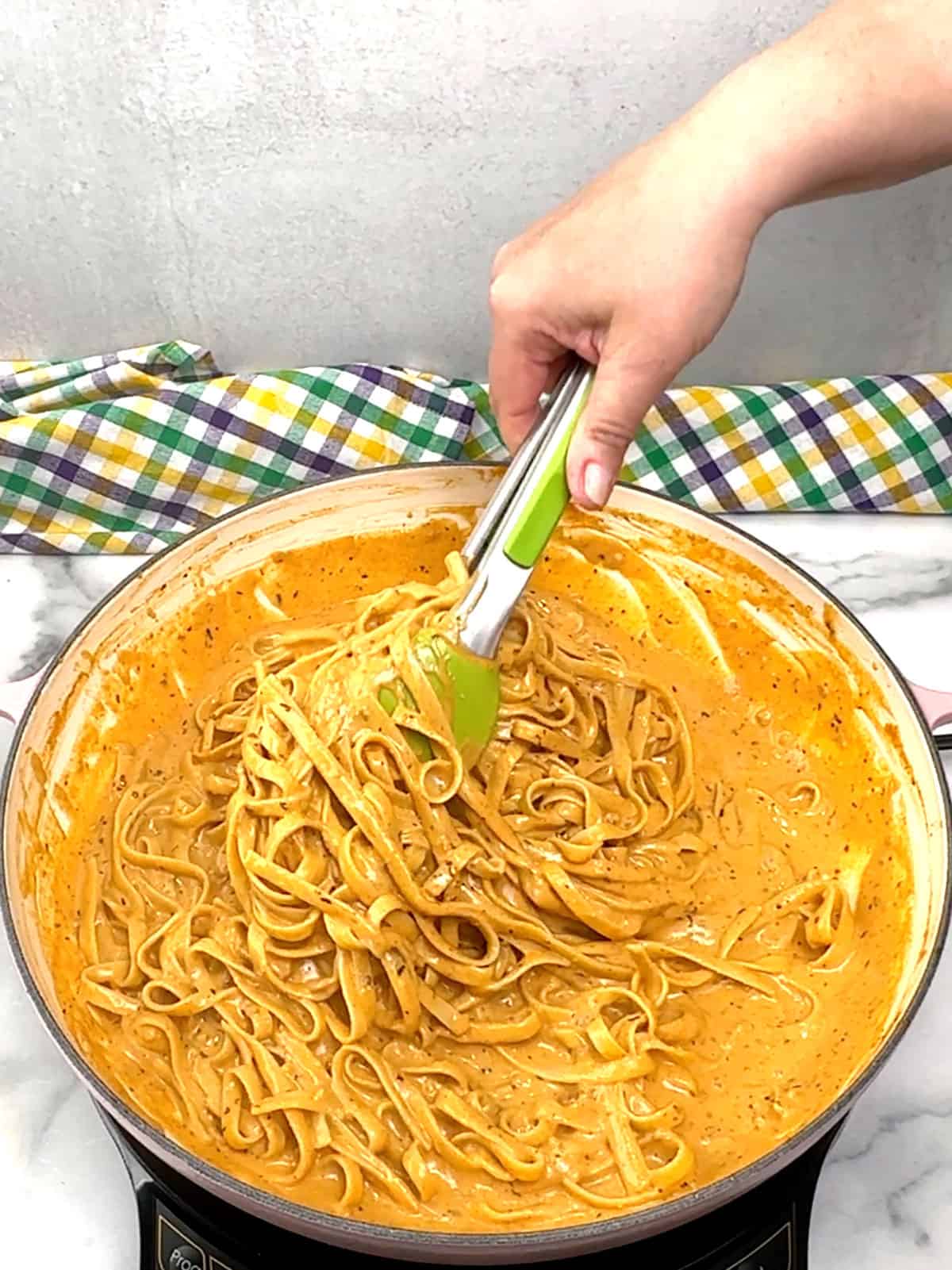 tossing pasta with sauce