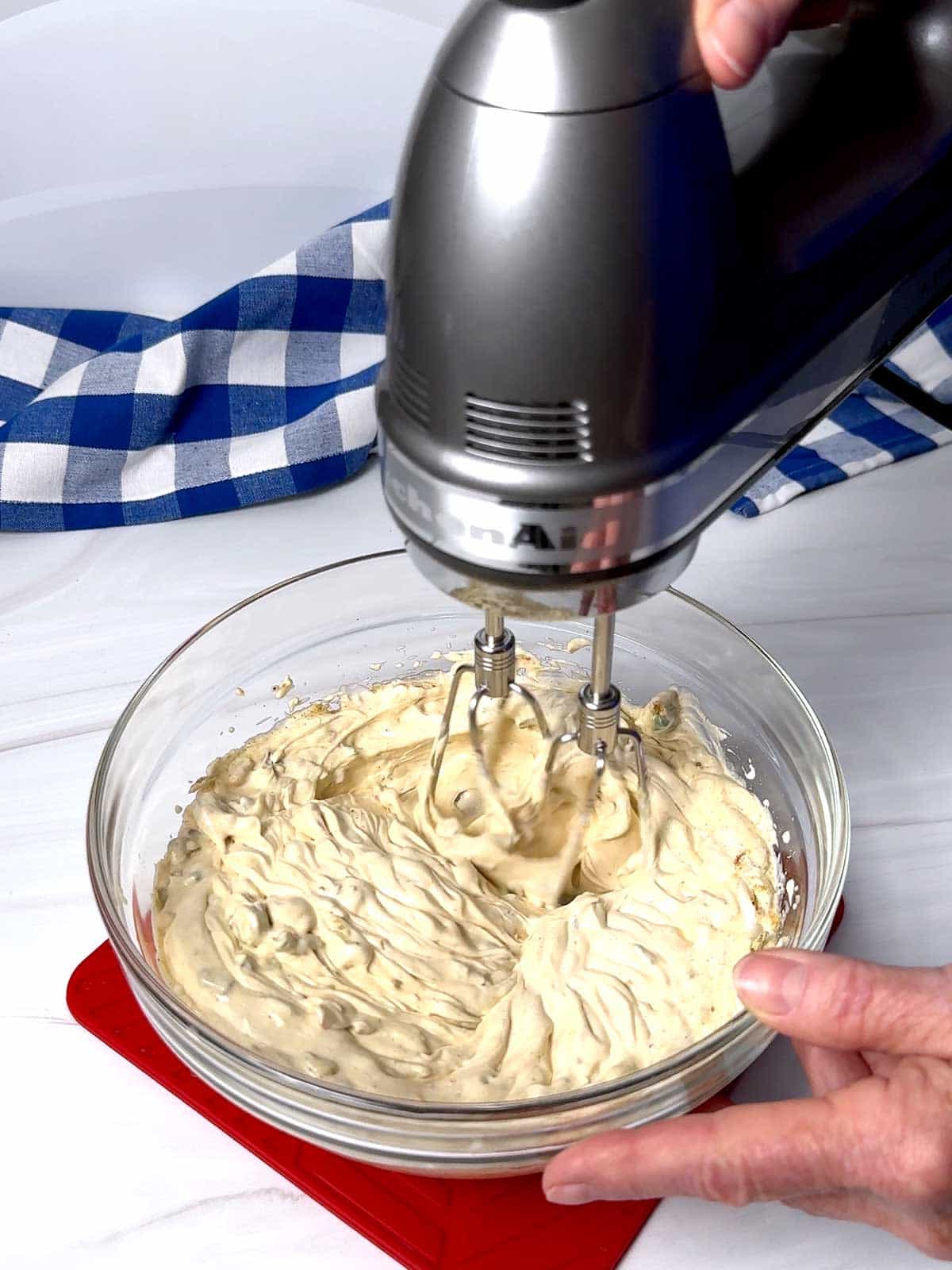 Beating the sour cream, mayonnaise and vegetable recipe mix in a medium bowl.