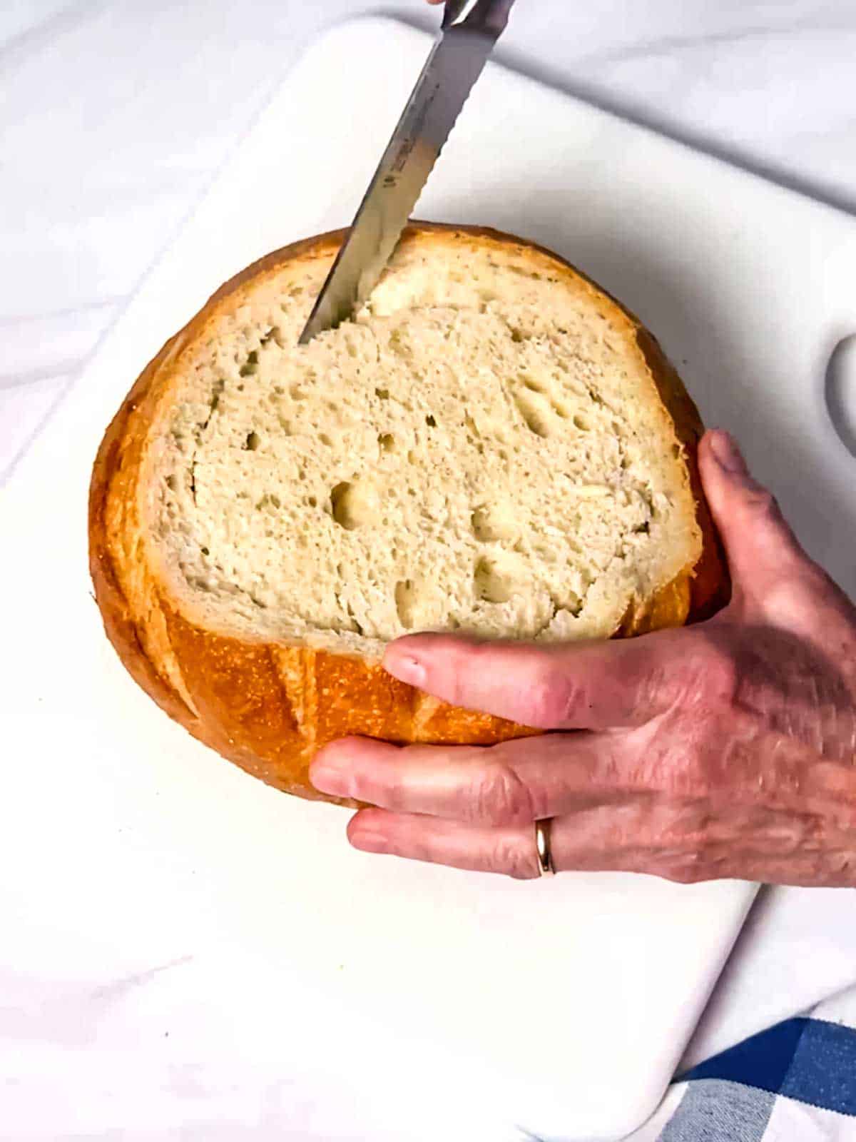 Cutting interior of bread round.