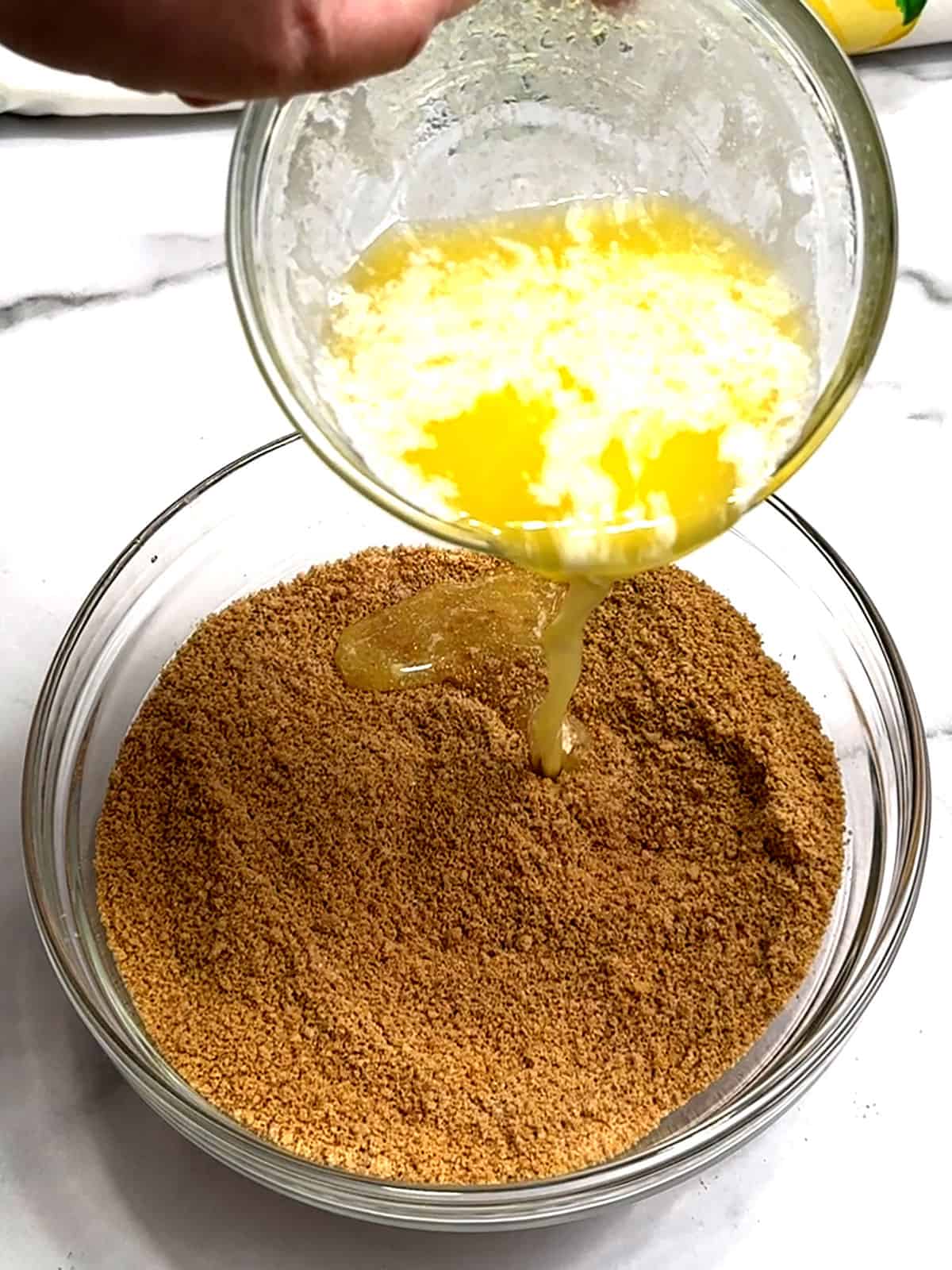 adding butter to graham cracker crumbs for crust