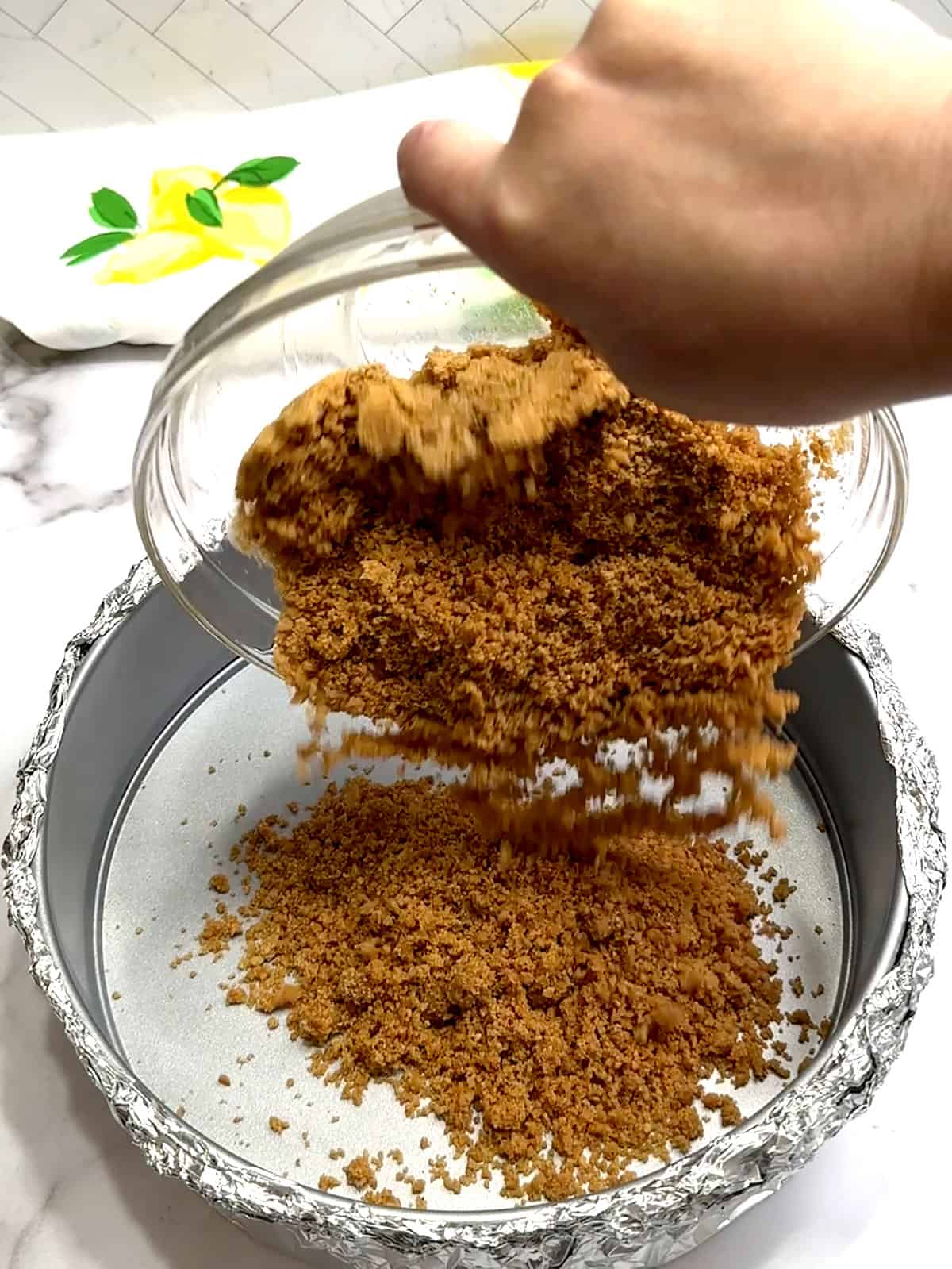 adding crust mixture to prepared pan