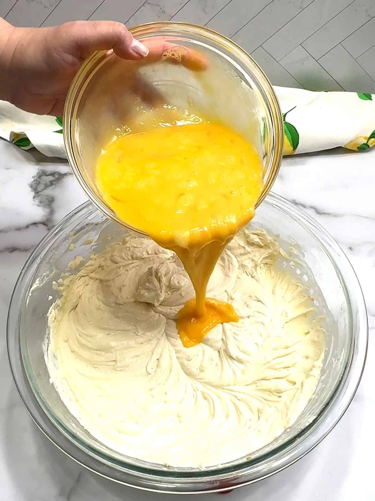 adding whisked eggs to cheesecake filling