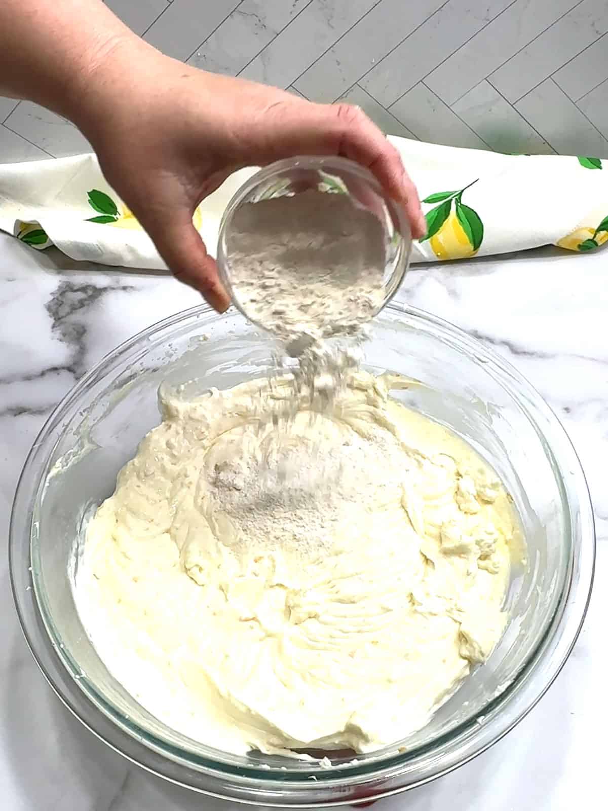 adding flour to cheesecake filling