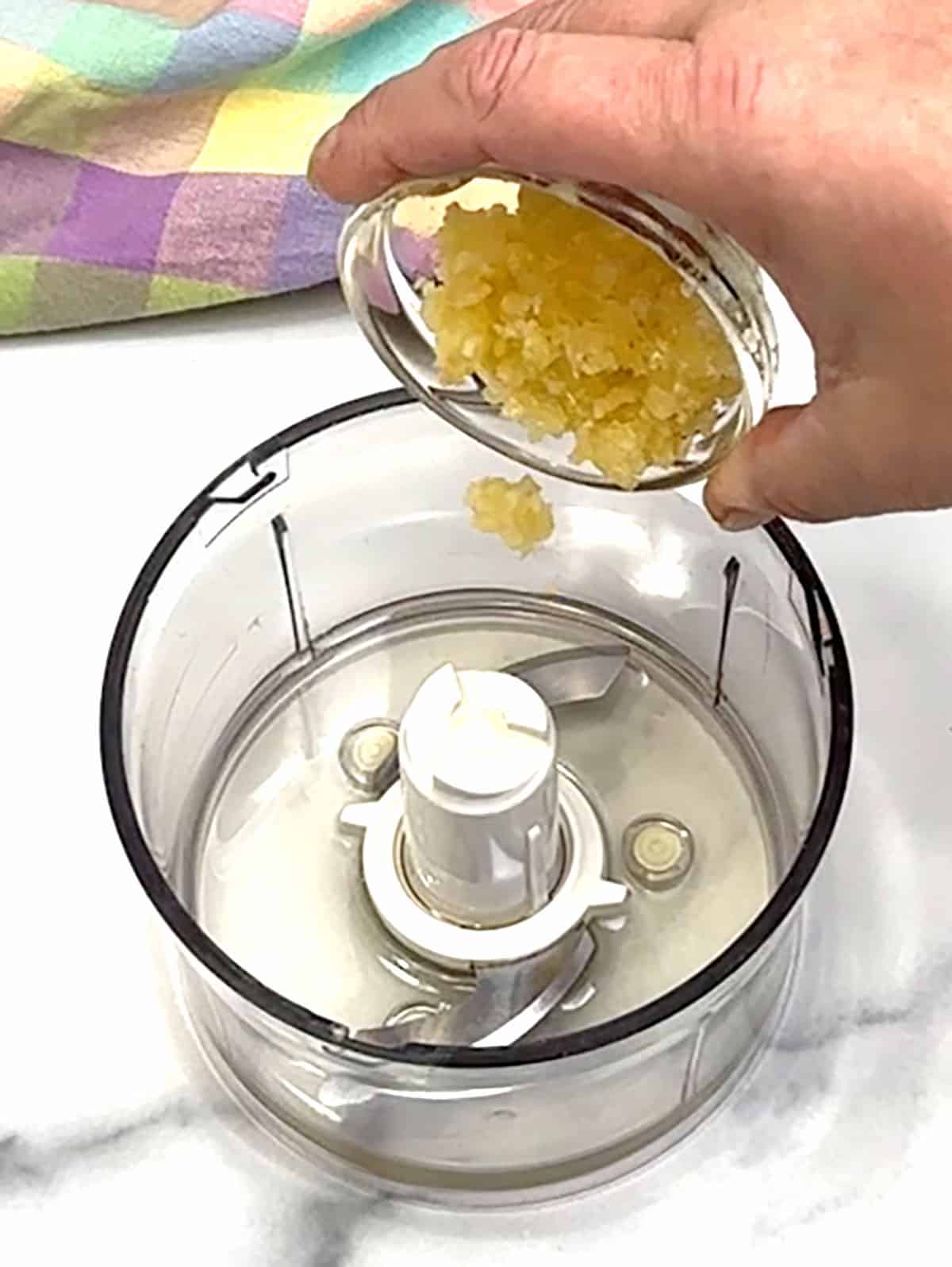 adding garlic to food processor