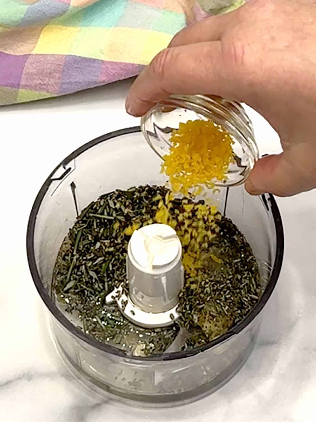 adding herbs and lemon zest to food processor