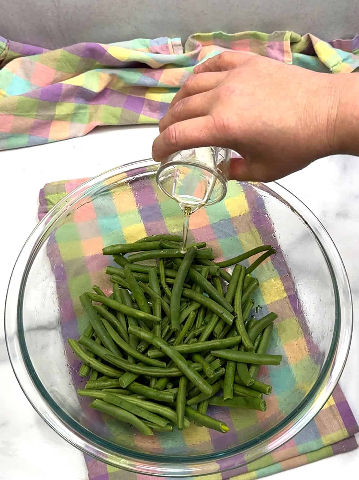 pouring oil over green beans