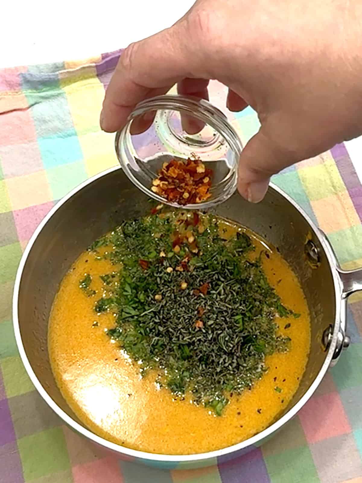 adding herbs and red pepper flakes to butter