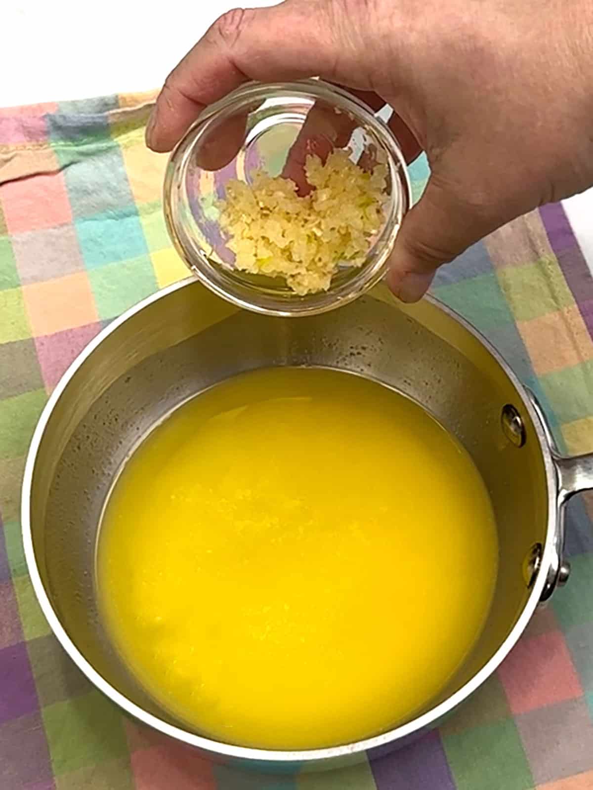 adding garlic to melted butter