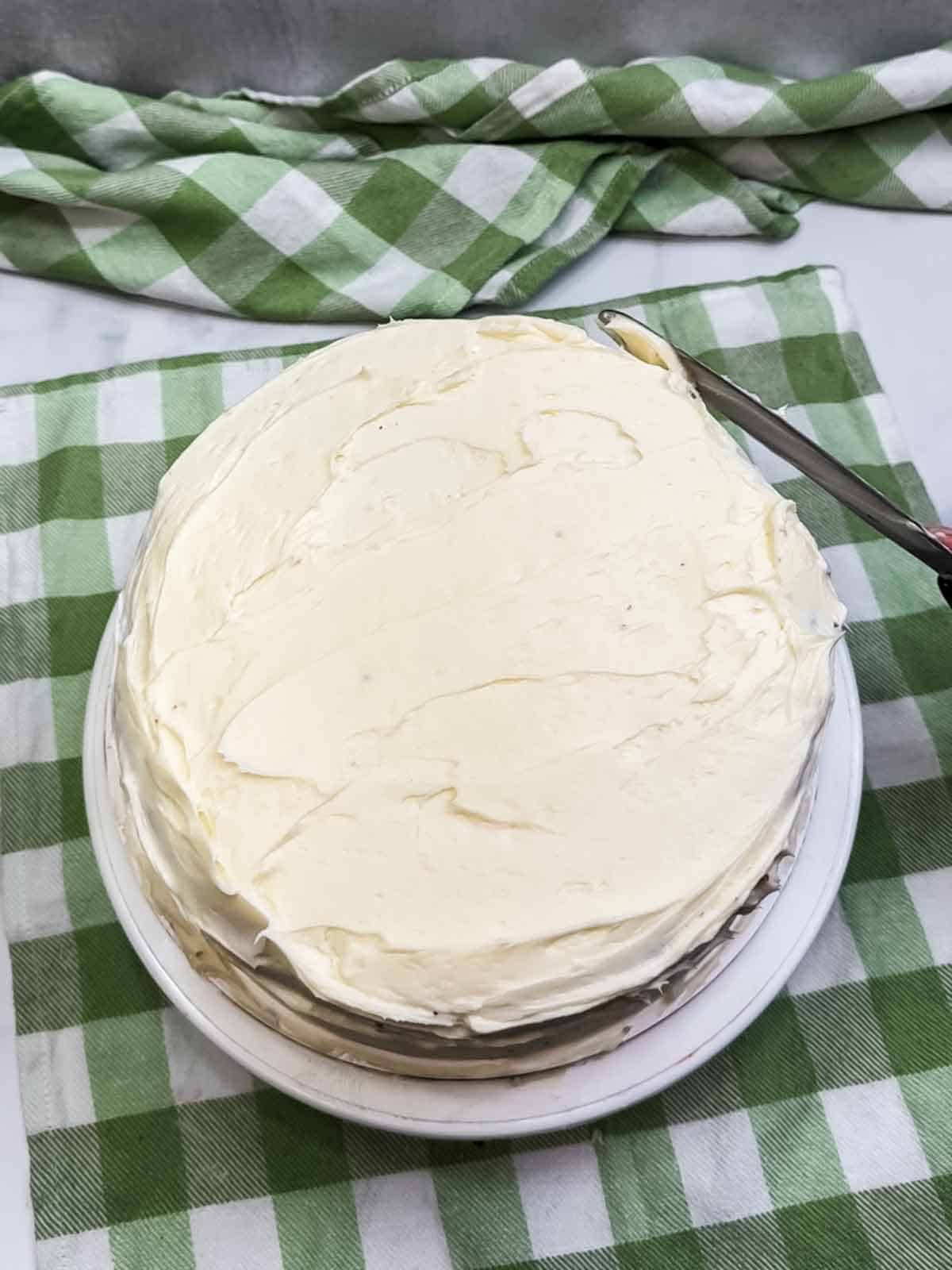 Frosting top and sides of carrot cake