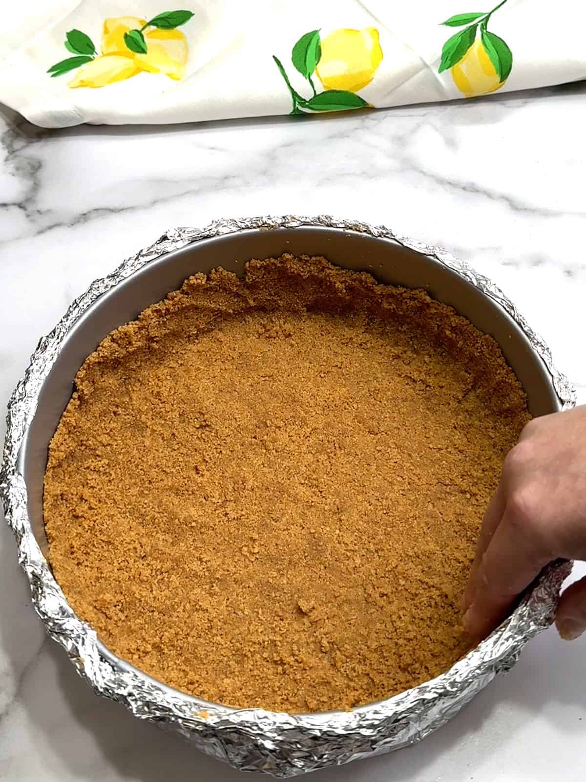 pressing crust into prepared pan