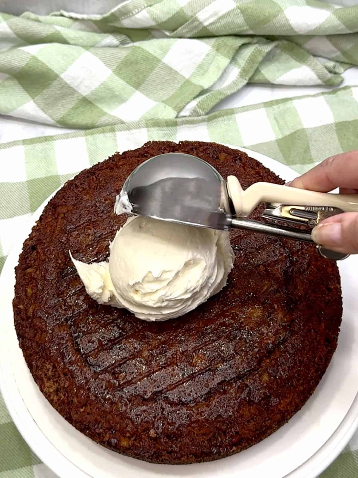 adding frosting to first cake layer