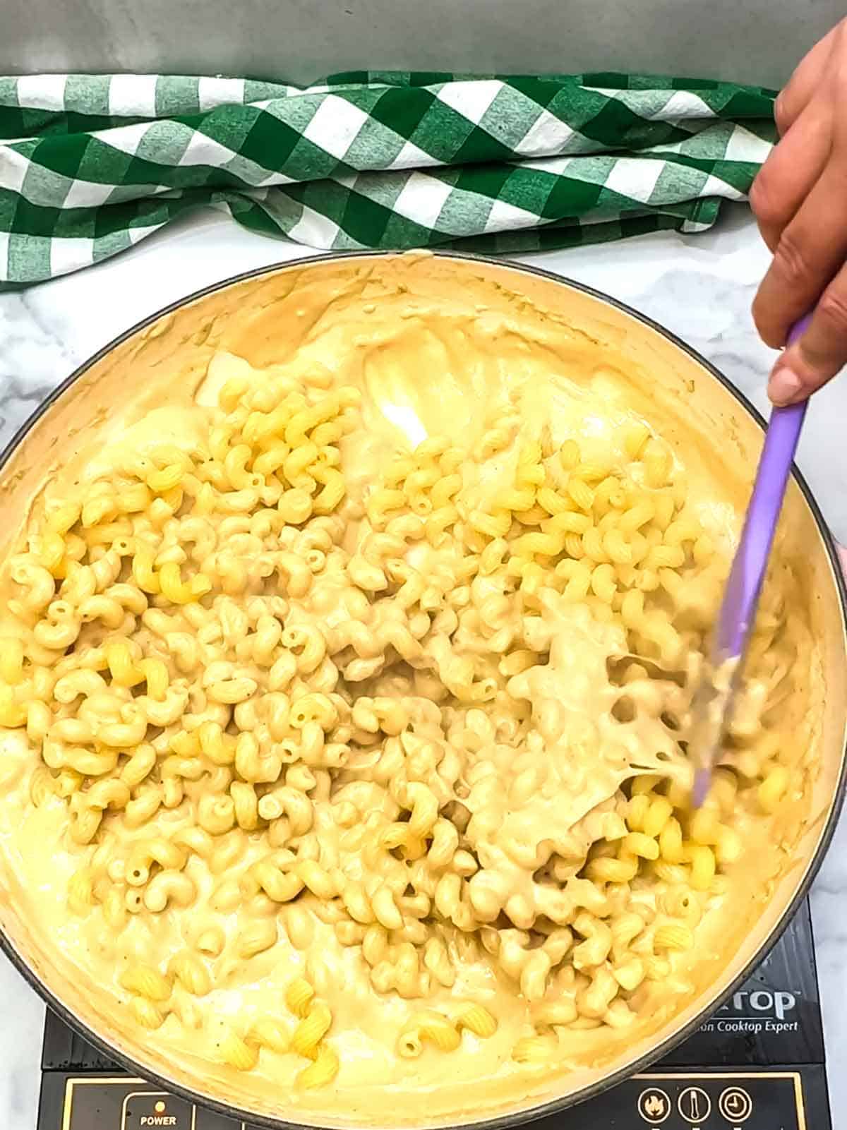 stirring pasta into the sauce