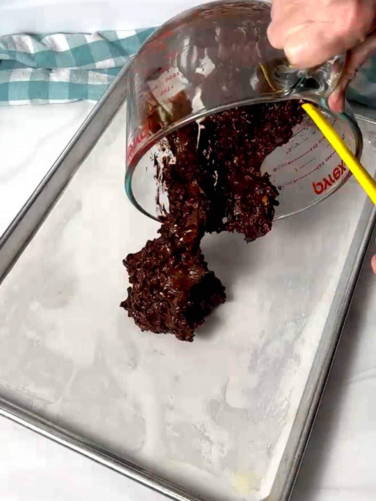 Transferring the brownie brittle to a parchment-lined half-sheet pan.