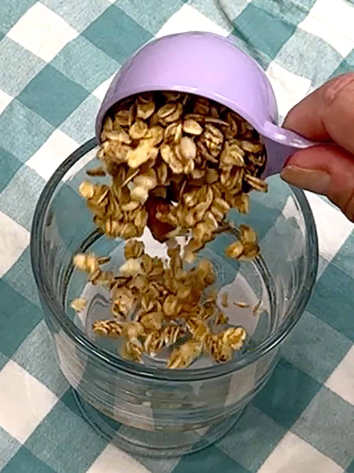 adding first layer of granola to glass