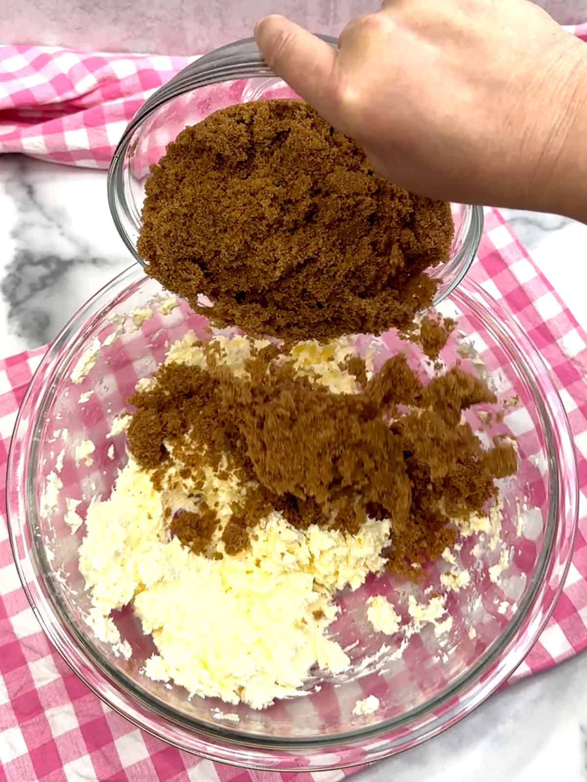 adding dark brown sugar to beaten butter