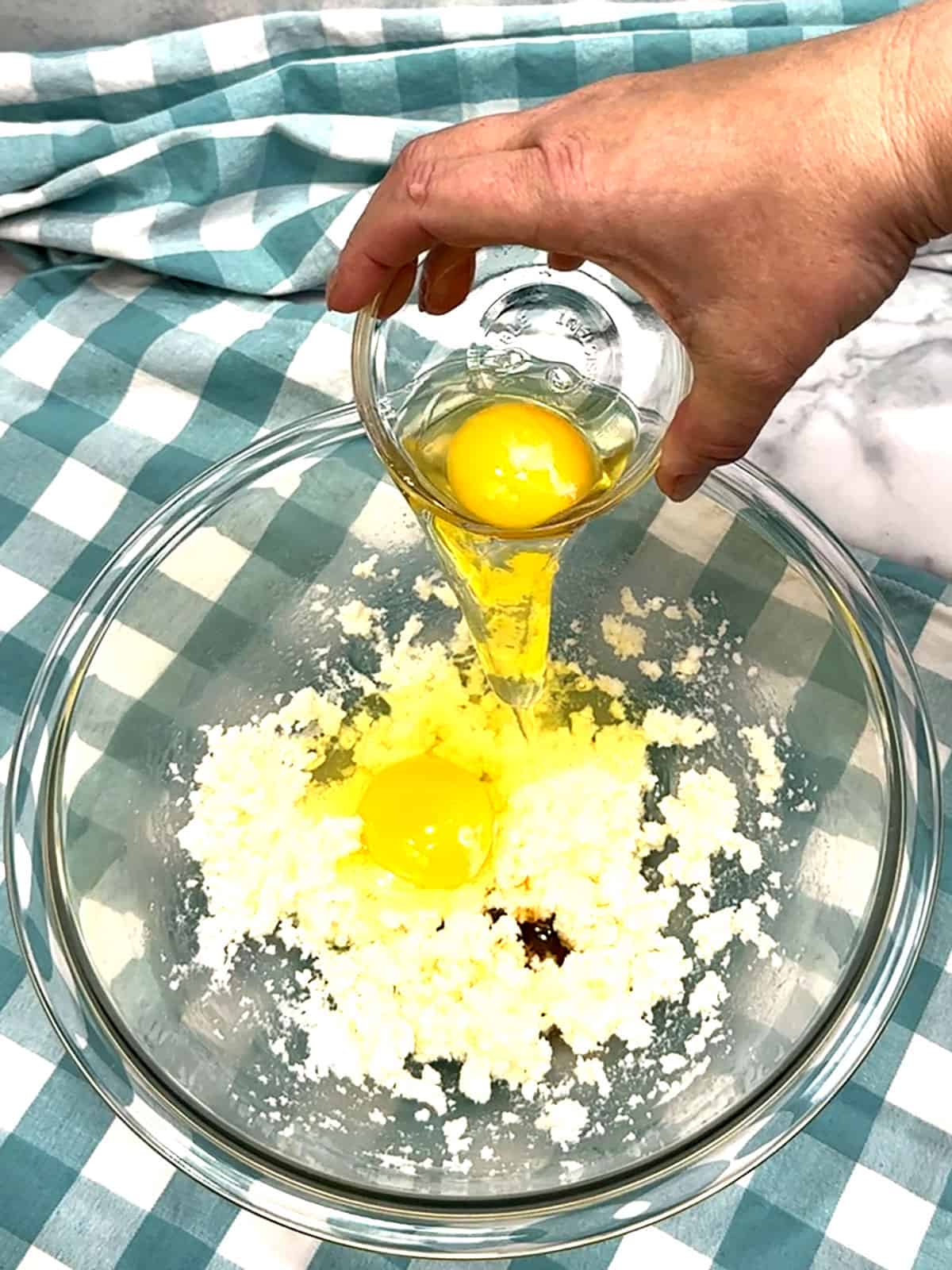 adding eggs and vanilla to beaten butter and sugar